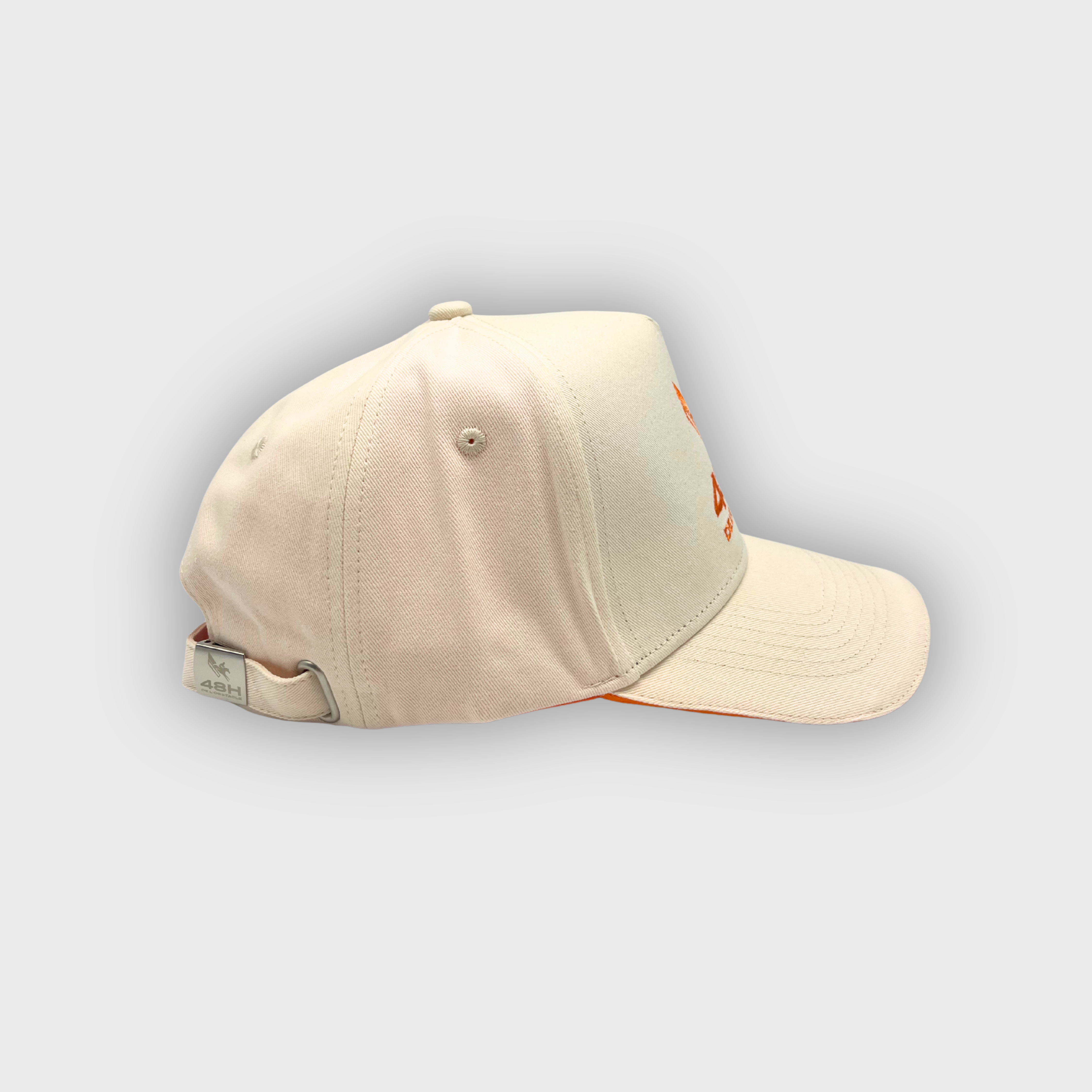ベージュとオレンジのロゴが入った48時間障害キャップ
